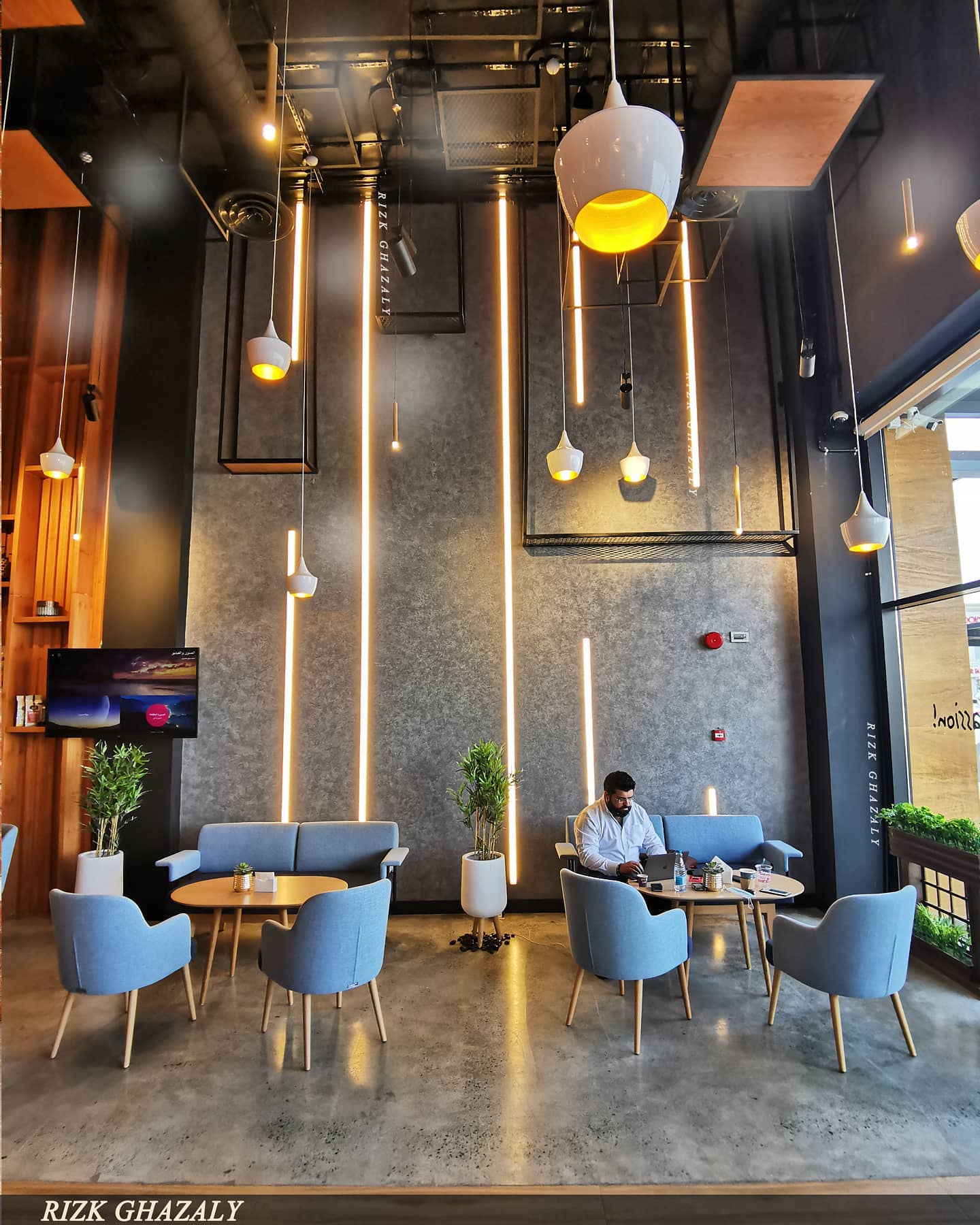 Completed Town Center café seating area with concrete wall and suspended lighting